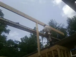 Carpenter setting a ridge beam over a new addition frame — Ice Dam Removal by Roofing Brothers in Wendover