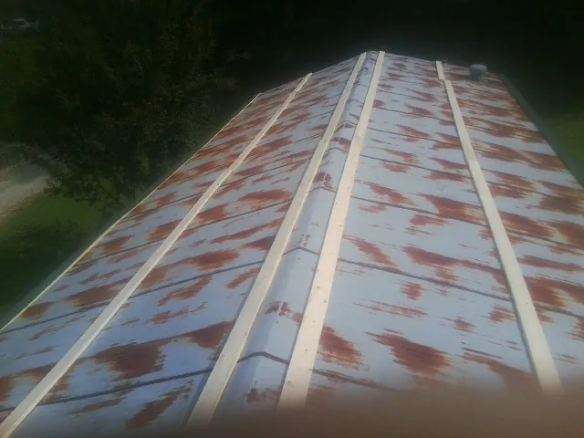 Rusted metal roof panels with new wood purlins before replacement — Storm Damage Roof Repair in Wendover by Roofing Brothers