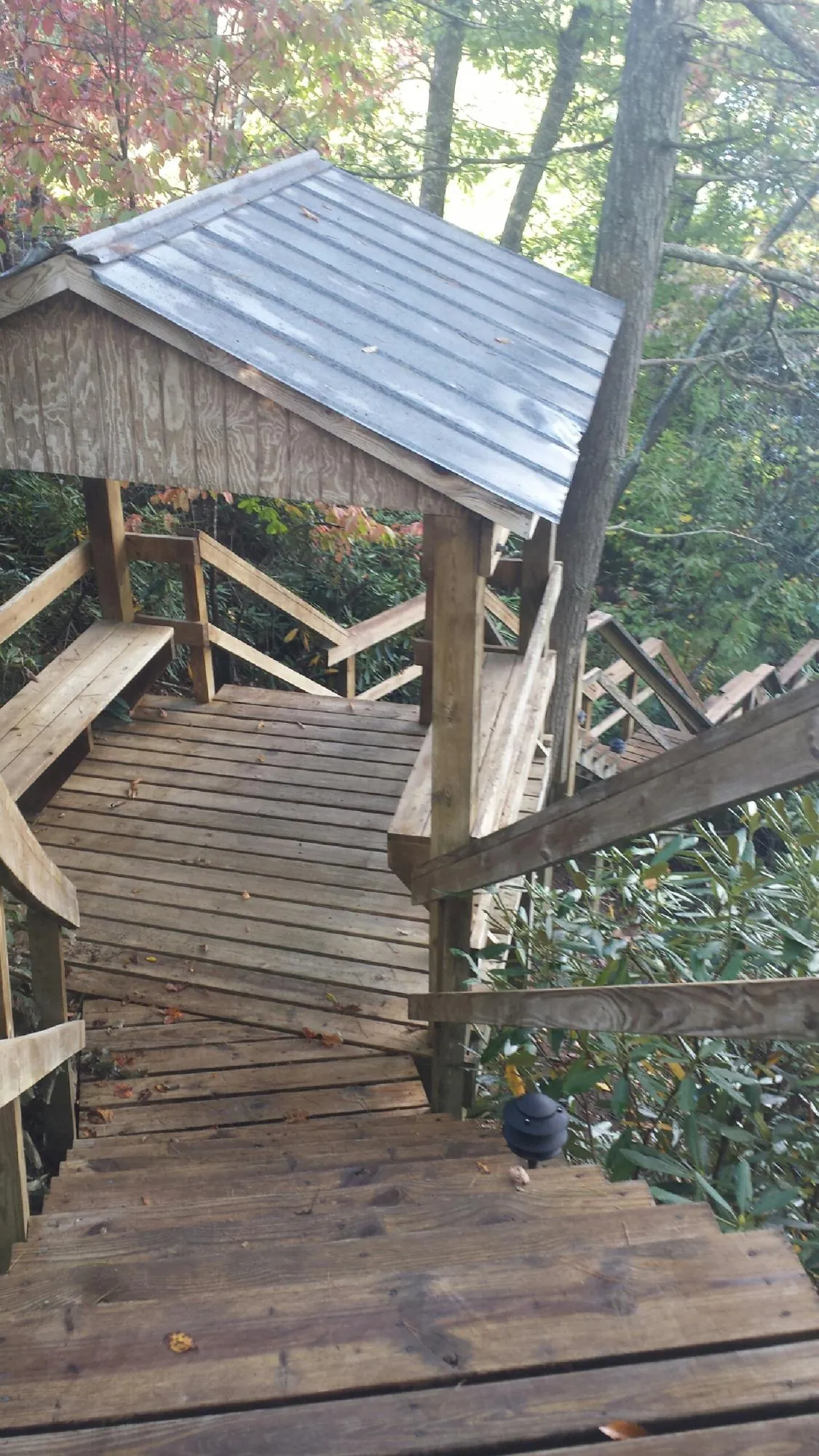 Metal roofed shelter over wooden steps on a wooded walkway — Skylight Repair & Installation work by our crew in Wendover